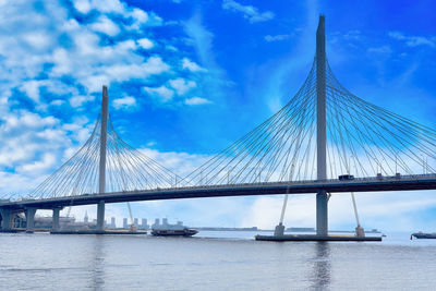 Suspension bridge over river against sky