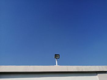 Low angle view of communications tower against blue sky