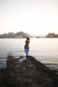 Full length of man standing in sea against clear sky