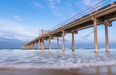 Low angle view of pier over sea against sky