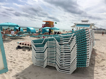 View of seats on beach against clouds