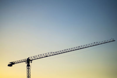 Low angle view of crane against clear sky