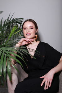 Portrait of young woman standing against white background