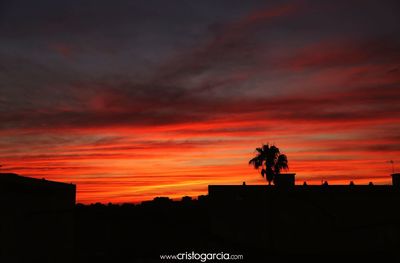 Low angle view of silhouette building against dramatic sky