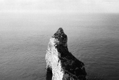 Rock formation in sea against sky