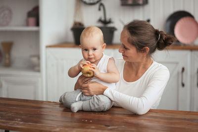 Portrait of cute girl sitting on bed at home