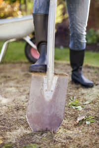 Low section of woman with foot on shovel at garden