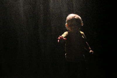 Silhouette of young child against dark background