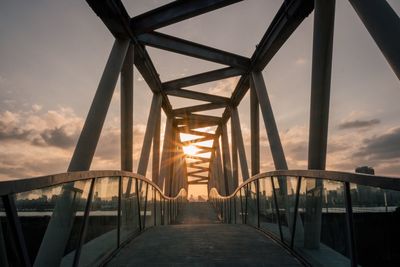 Bridge in city against sky during sunset