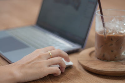 Midsection of man using laptop on table