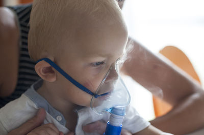 Close-up portrait of cute boy drinking