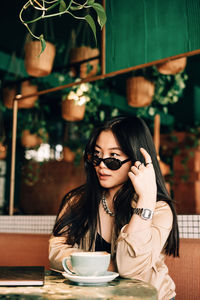 Portrait of a woman with coffee cup on table at restaurant