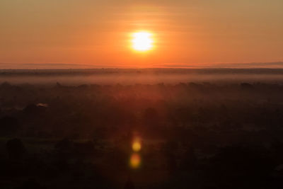 Scenic view of silhouette landscape against orange sky