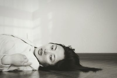 Close-up of young woman lying on floor 