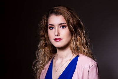 Portrait of woman against black background