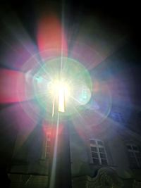 Low angle view of sunlight streaming through illuminated bright sun