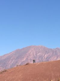 Scenic view of desert against clear blue sky