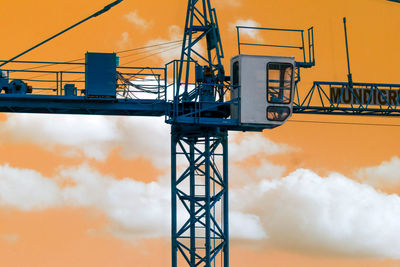 Crane at construction site against sky during sunset