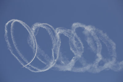 Low angle view of airplane flying against blue sky