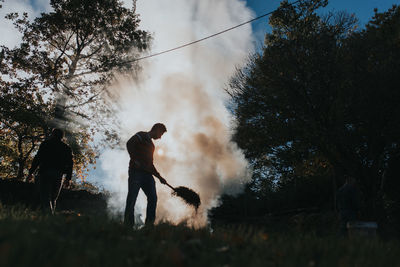 Man burning hay on field