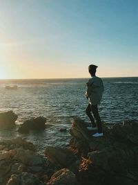 Rear view of man looking at sea against sky