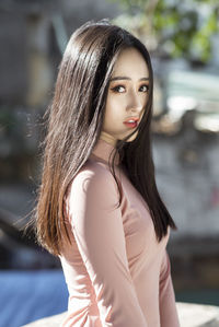 Portrait of beautiful young woman standing outdoors