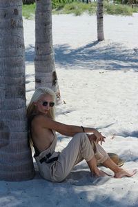 Rear view of woman sitting on snow covered field