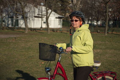 Man standing by bicycle on field