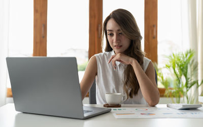 Young woman using laptop at office