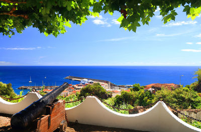 High angle view of town by sea against sky