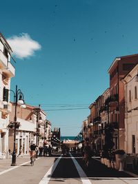 People on road against buildings in city