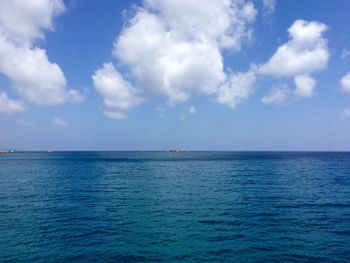 Scenic view of blue sea against cloudy sky