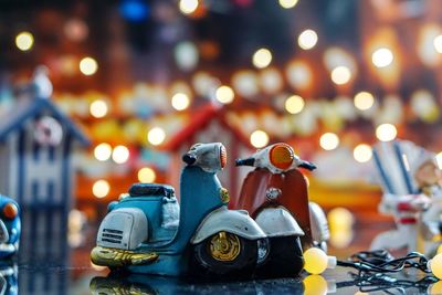 Close-up of toys on table against illuminated lights