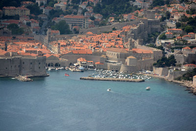 High angle view of town by harbor at sea