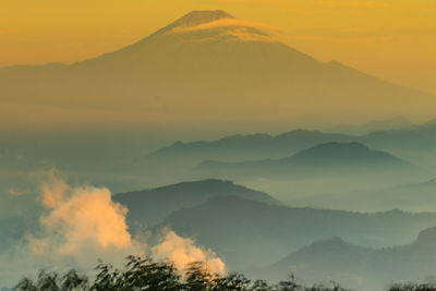 Scenic view of silhouette mountains against sky during sunset