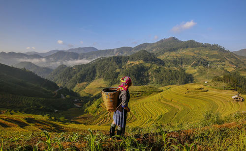 Man standing on agricultural field against sky