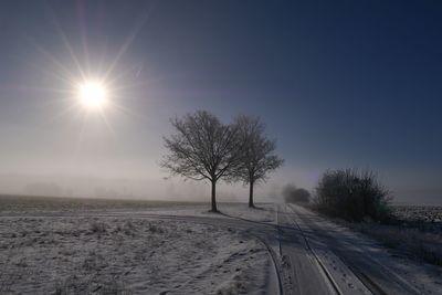 Scenic view of snow covered field against sky