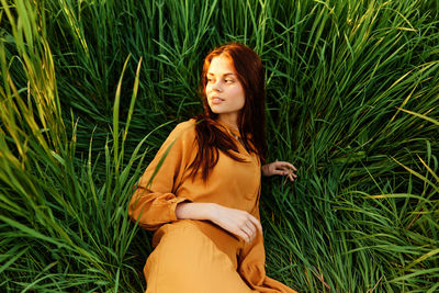 Portrait of young woman standing on grass