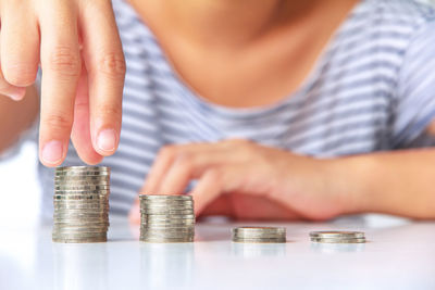 Close-up of hand holding coins on table