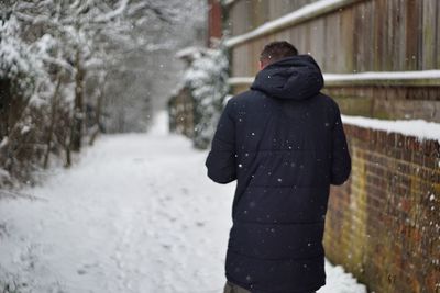 Rear view of man standing in snow