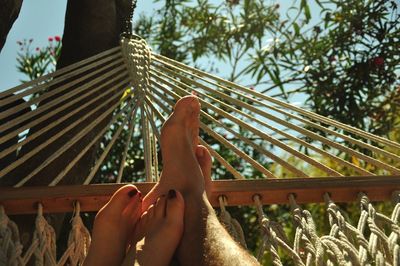 Low section of couple relaxing on hammock