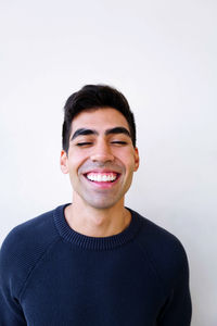 Portrait of smiling young man against white background