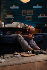 Depressed man sitting on sofa at home