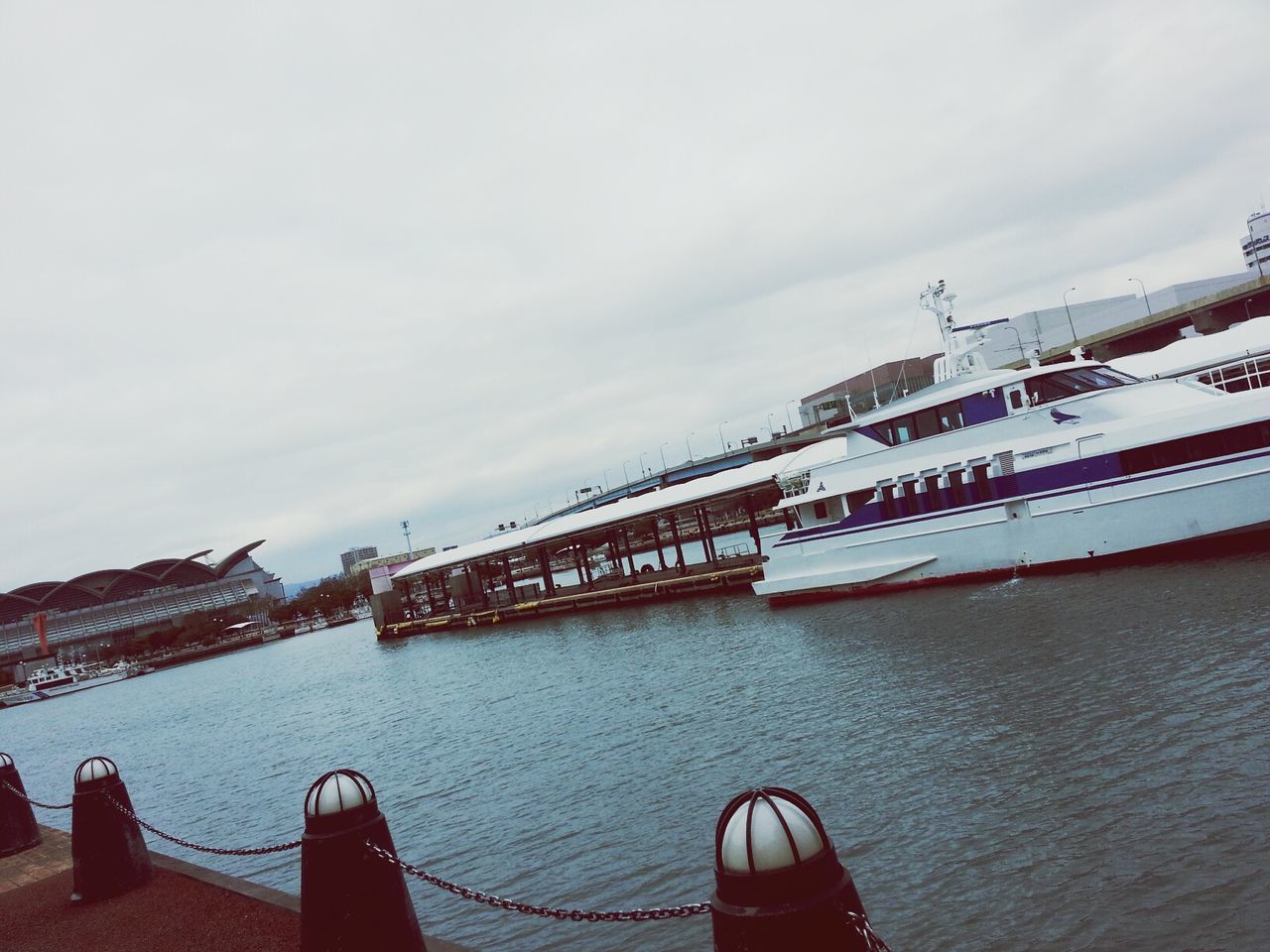 sky, built structure, architecture, cloud - sky, water, building exterior, cloudy, weather, pier, outdoors, day, bridge - man made structure, railing, cloud, connection, sea, nature, nautical vessel, one person, transportation