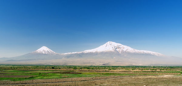 Scenic view of snowcapped mountains against clear blue sky