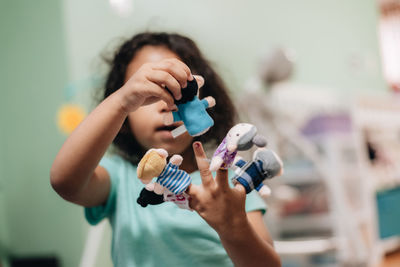 Close-up of cute girl holding toy at home