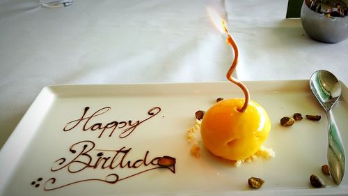 Close-up of candle on mousse ball in tray