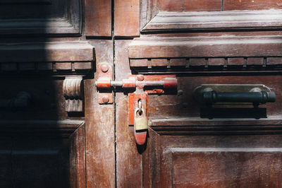 Close-up of padlock hanging on wooden door