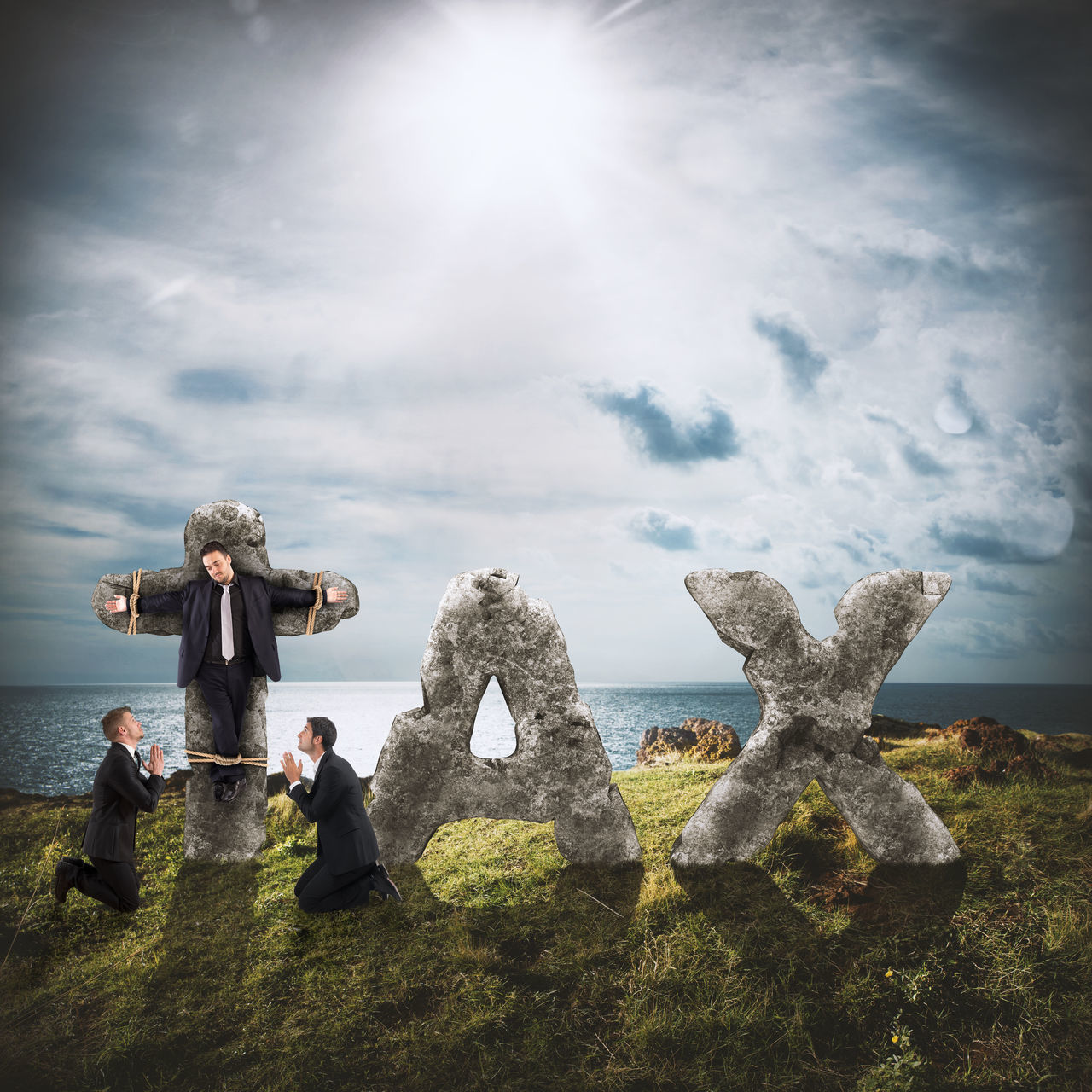 PEOPLE SITTING ON FIELD BY ROCK AGAINST SKY