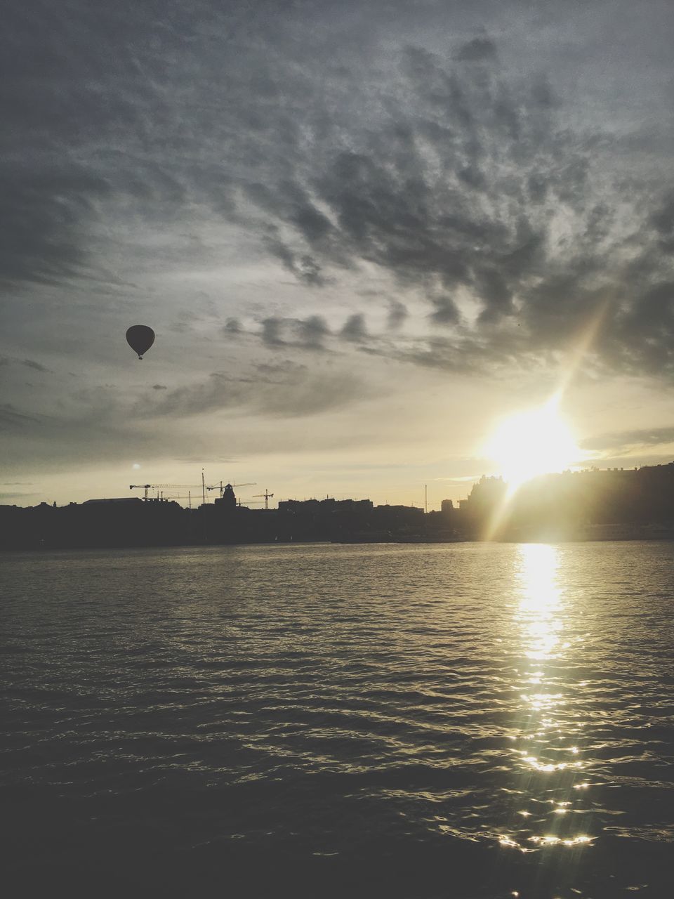 sunset, sun, sunbeam, sunlight, reflection, sky, silhouette, waterfront, nature, no people, outdoors, water, beauty in nature, scenics, flying, hot air balloon, day